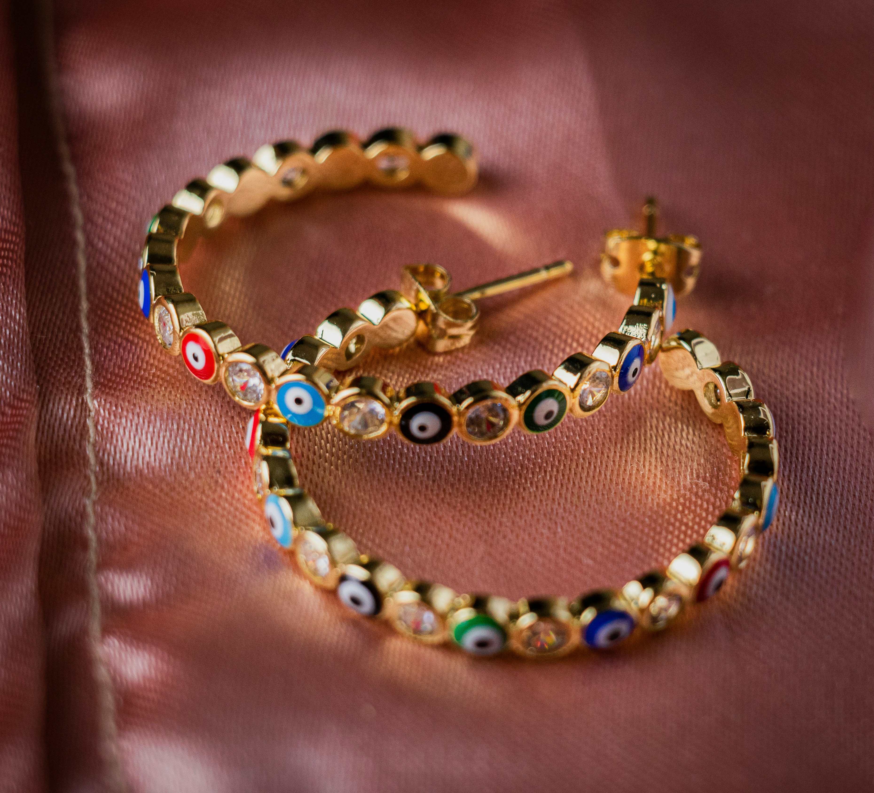 a close up of a pair of earrings on a cloth